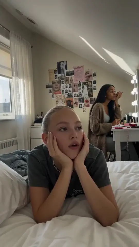 Aurora lying on a bed in a shared bedroom, a still from a clip made in AIGE